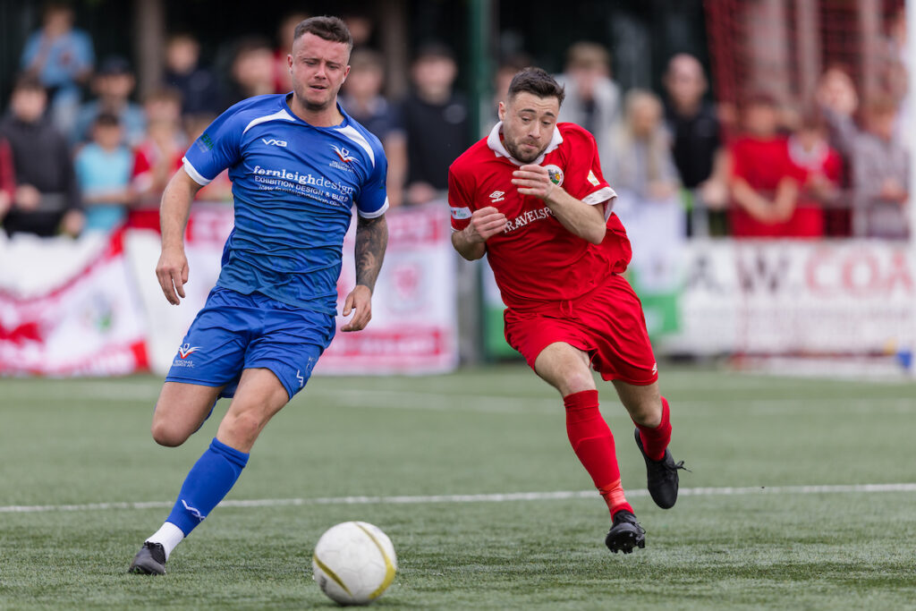 Denbighs Craig Pritchard and Trethomas' Andrew Evans during the 2022/23 FAW Amateur Trophy Final fixture between Denbigh Town FC & Trethomas Bluebirds AFC at Latham Park, Newtown, Wales, 29 April 2023