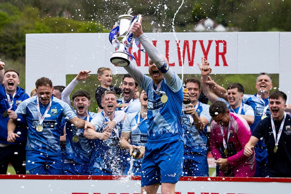 Port Talbot's Sam Baker lifts the trophy during the 2024/25 FAW Dragon Signs Amateur Trophy final between Port Talbot Town FC & Penygraig United FC at Ynys Park, Trefelin, Port Talbot, Wales
