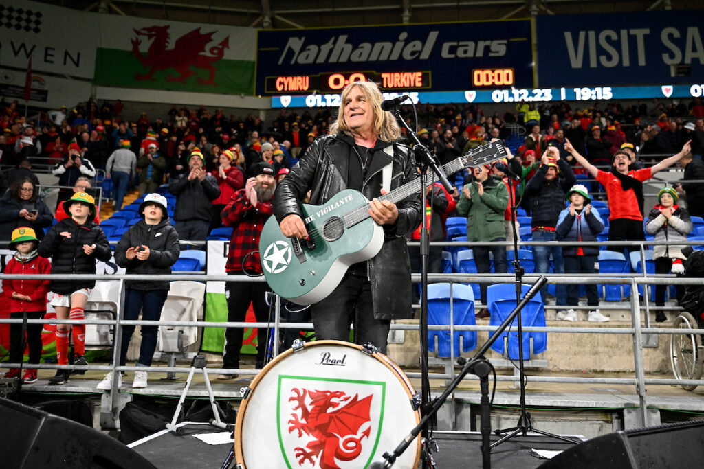 Mike Peters performs prior to the Group D 2024 European Championship Qualifying fixture between Wales and Turkey at the Cardiff City Stadium on the 21st of November, 2023. The FAW is deeply saddened by the news that he has passed away.