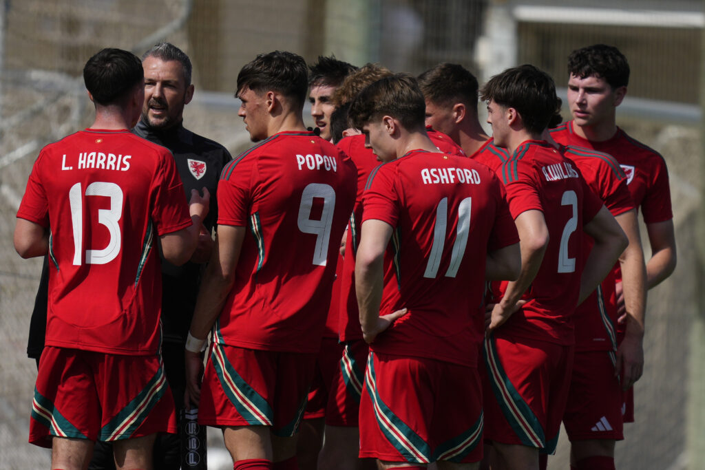 Cymru Under-21 boss Matty Jones speaks to his players during a match