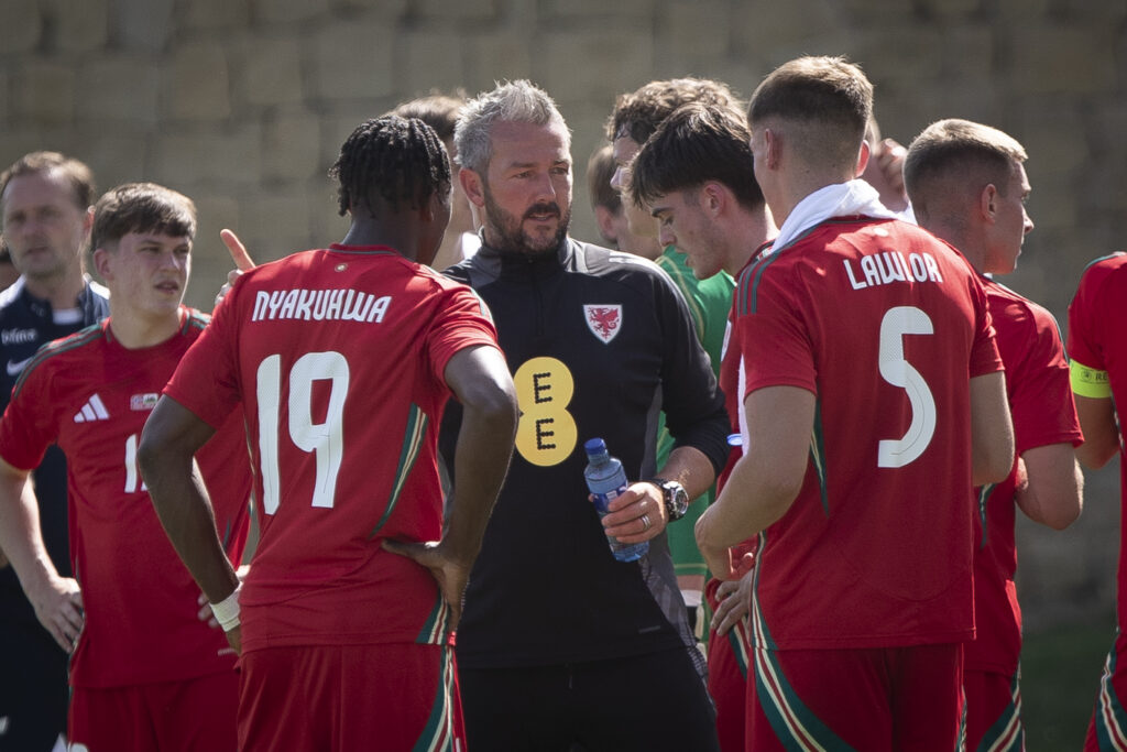 Cymru U21 boss Matty Jones speaks to Tanatswa Nyakuhwa (L) and Dylan Lawlor (R)