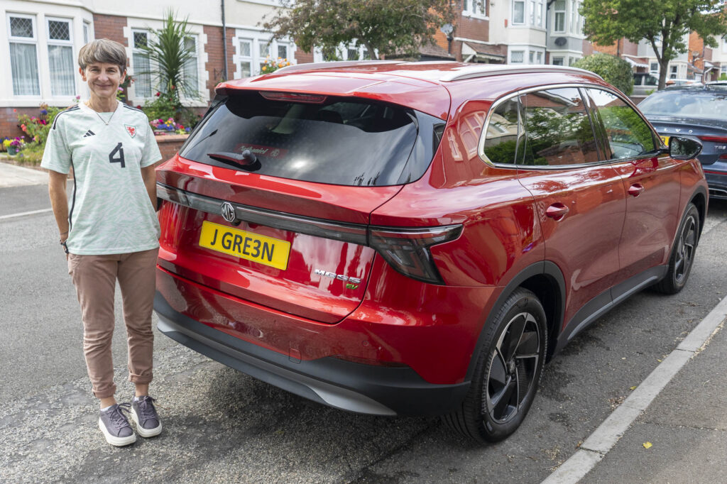 UEFA Vice President Laura McAllister in a Cymru shirt stood next to a Nathaniel MG car as part of the UEFA Women's EURO 2025 squad announcement.