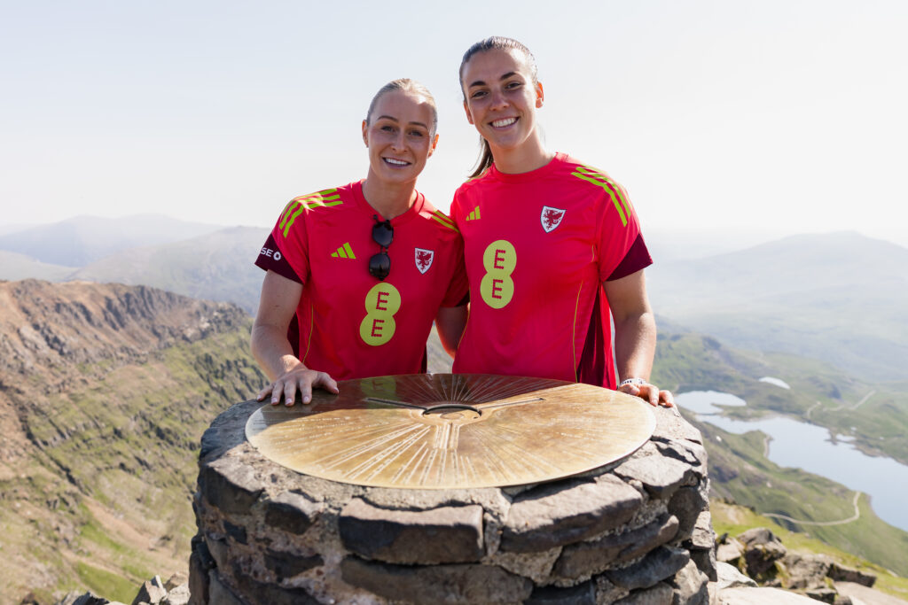 Rhiannon Roberts (L) and Olivia Clark (R) at the summit of Yr Wyddfa as part of the Cymru UEFA Women's EURO 2025 squad announcement.