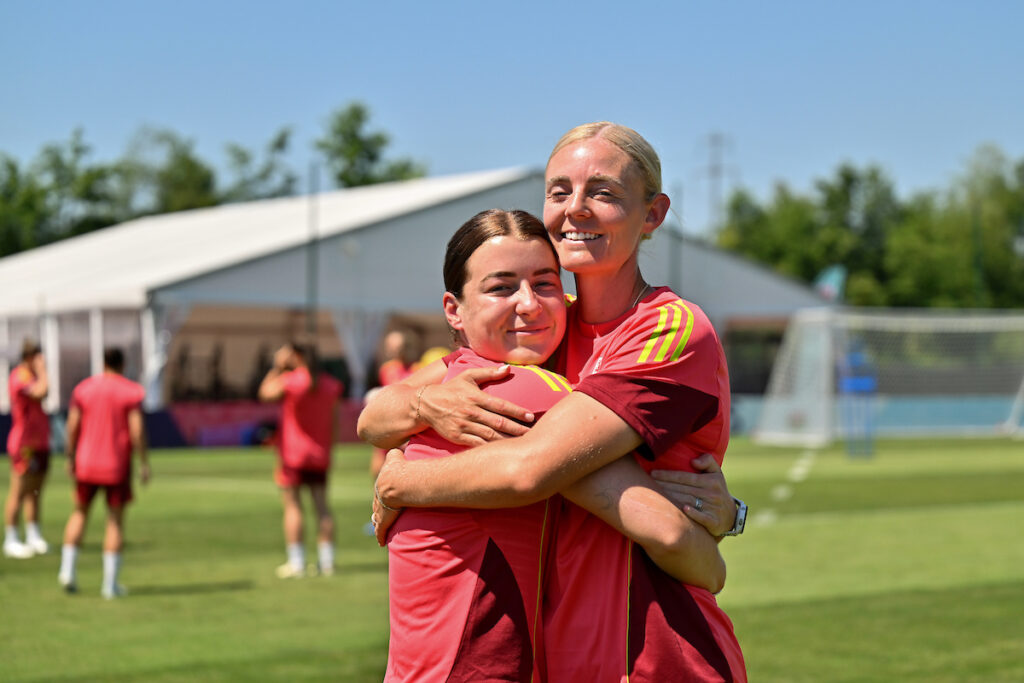 Angharad James and Sophie Ingle hug at a Cymru training session at UEFA EURO 2025