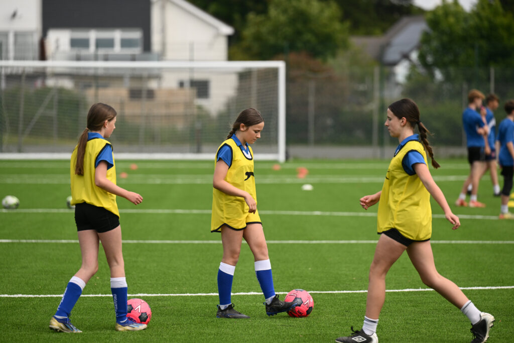 school pupils playing football